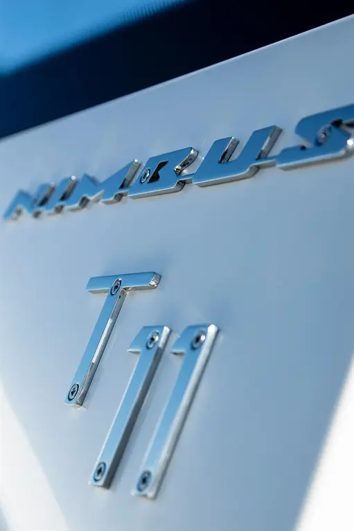 Close-up of the Nimbus T11 branding in shiny chrome on a white surface, highlighting the model name and detail design.